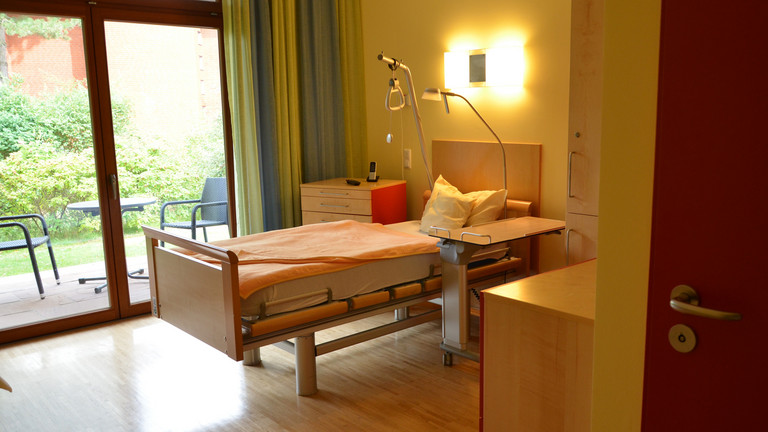Blick in Gästezimmer mit Blick auf Terrasse - Diakonie Hospiz Volksdorf