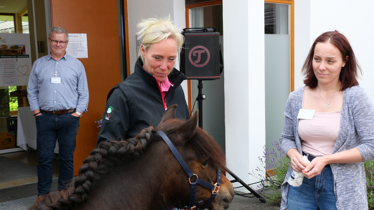 Pony Selma mit Besitzerin Hanna Lüthje und Hospiz-Mitarbeiterin Enya Appel, im Hintergrund Seelsorger Pastor Roger Bahr, beim Sommerfest Diakonie Hospiz Volksdorf