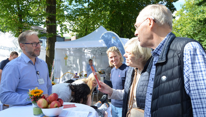 Ein Mann und eine Frau im Gespräch mit Chefarzt Anästhesiologie und Intensivmedizin Prof. Dr. Matthias Grünewald an den Ständen des Gesundheitscampus Volksdorf der Immanuel Albertinen Diakonie beim Stadtteilfest Volksdorf 